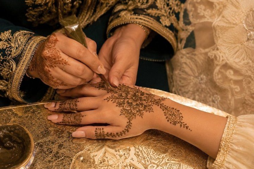 A person applying henna on another person's hand. 1