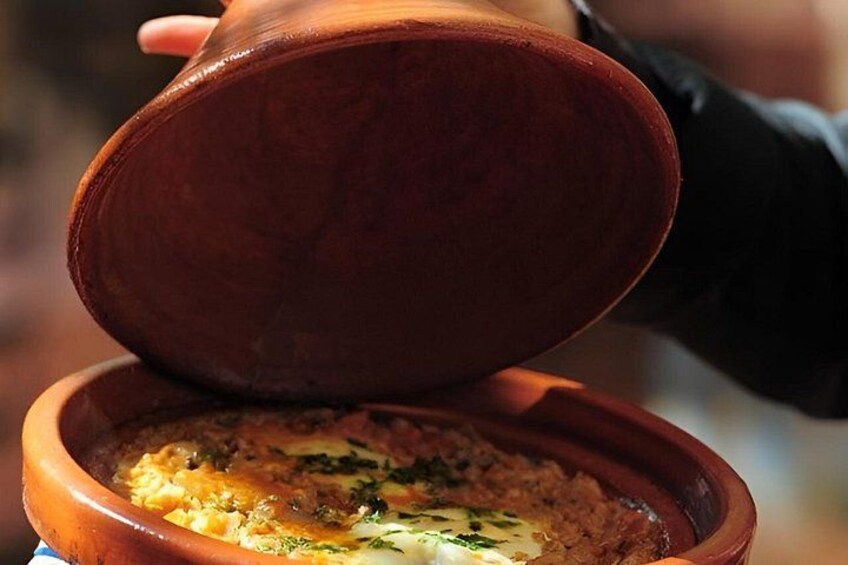 A person holding a clay pot over a dish. 3