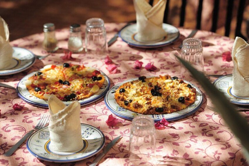 A table with plates of food, utensils, and napkins. 5