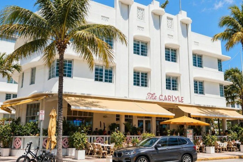 A white building with a yellow awning labeled 'The Carlyle.' 5