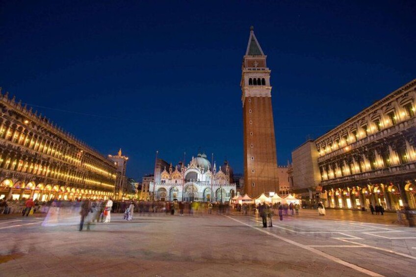 A historic square with a prominent clock tower and ornate buildings. 2