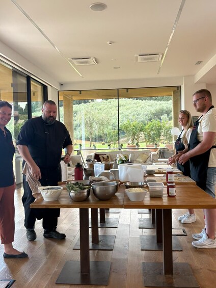Un groupe de personnes se trouve dans une cuisine moderne, avec une grande fenêtre donnant sur un jardin. 3