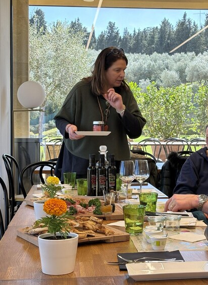 Une personne servant des plats à une table en plein air, avec vue sur des arbres et un ciel dégagé. 5