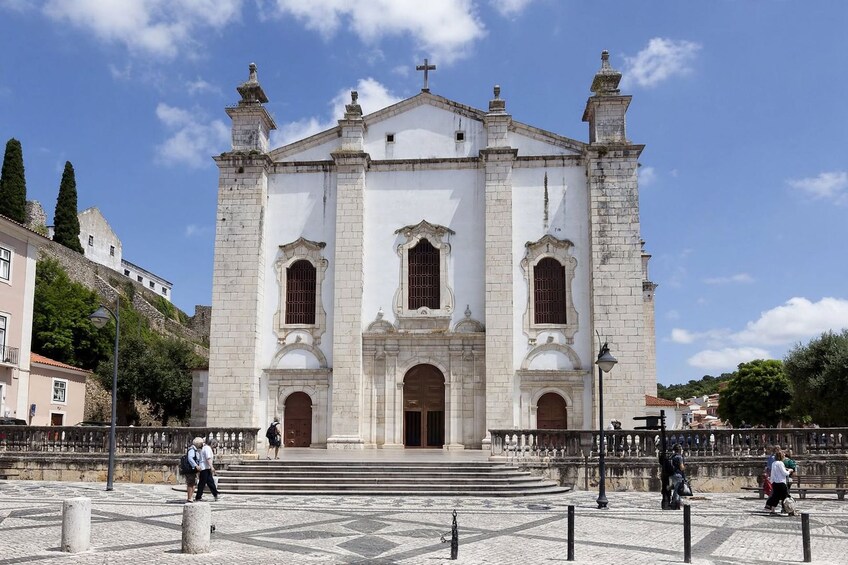 A historic church with a prominent facade, large arched windows, and a bell tower. 2