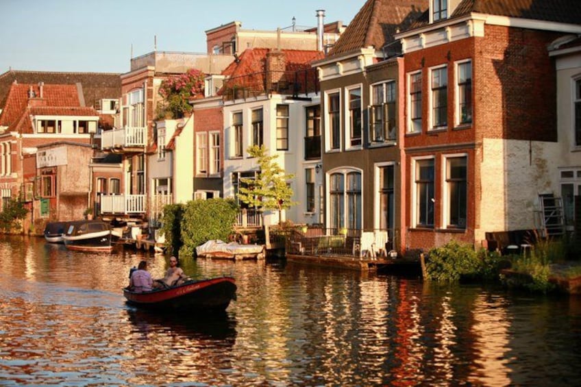 A canal with boats, traditional buildings, and a person in a boat. 4