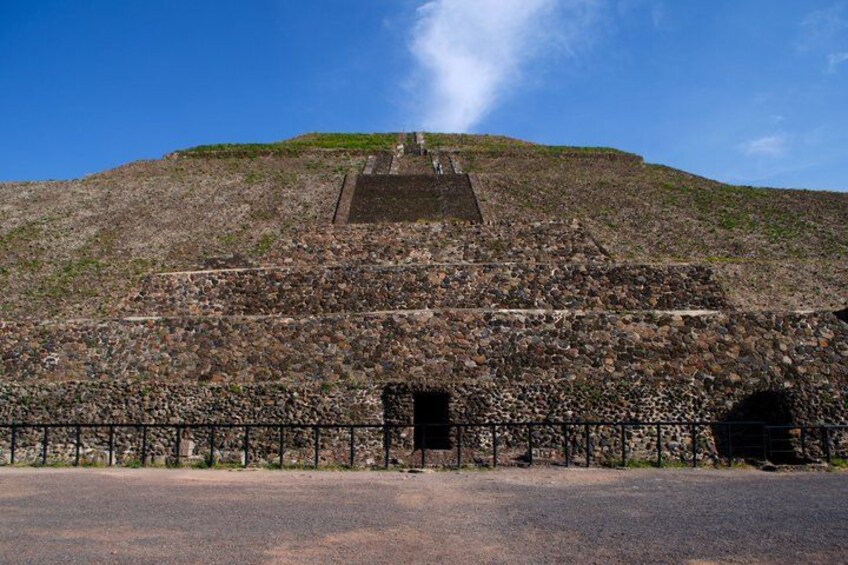 A large stone pyramid with a staircase leading to the top, surrounded by a fence. 2