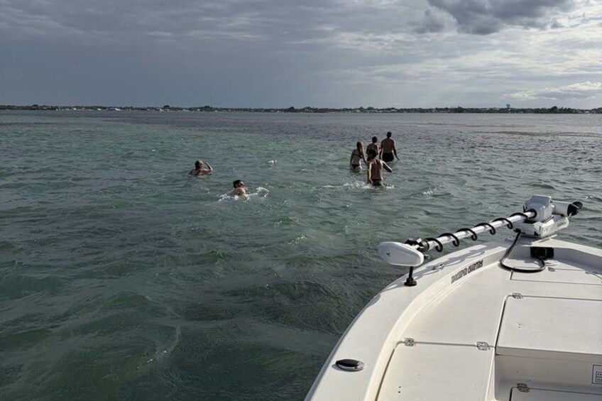 A boat with people swimming in the water. 5