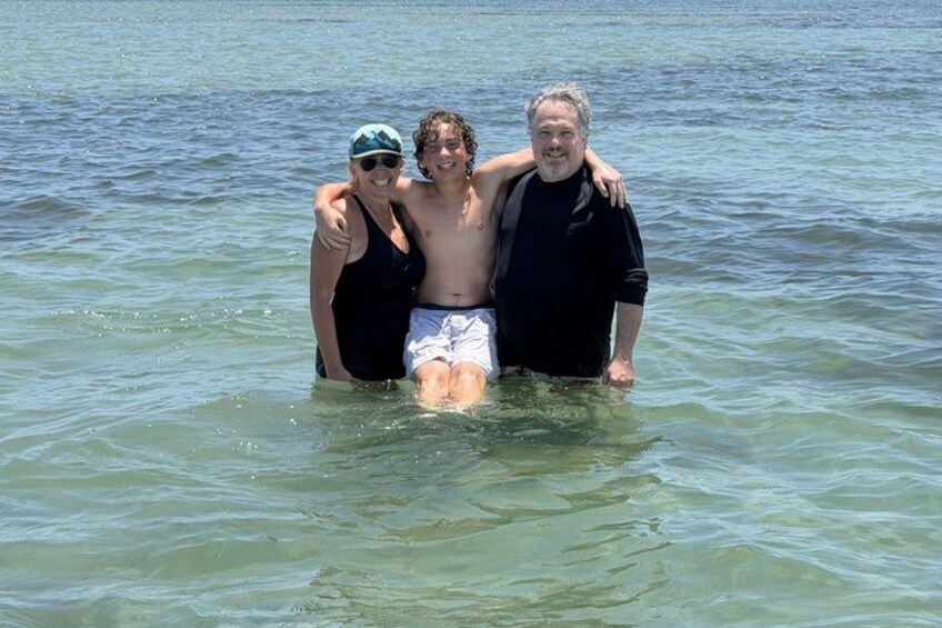 Three people standing in shallow water. 3