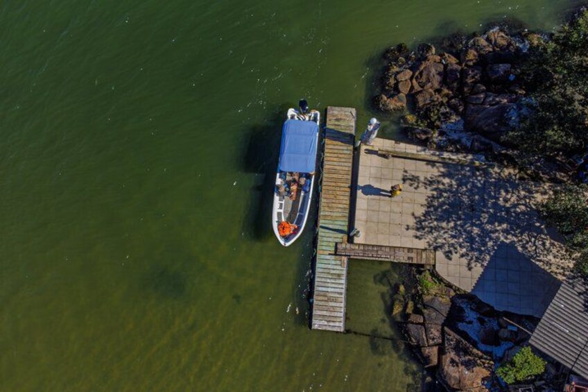 A boat docked at a pier, surrounded by calm water and a rocky shoreline. 4