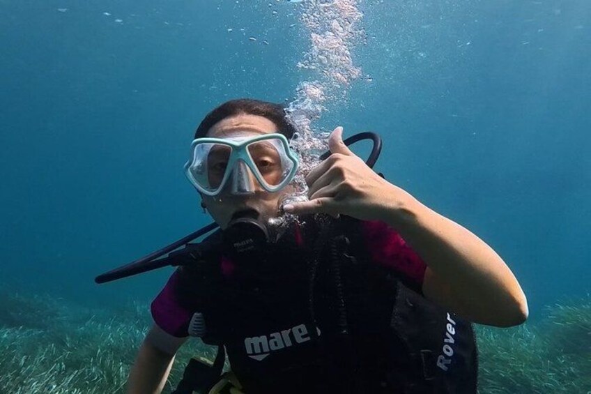 A person underwater, wearing a scuba diving mask and breathing apparatus, with bubbles rising from the mouth. 4