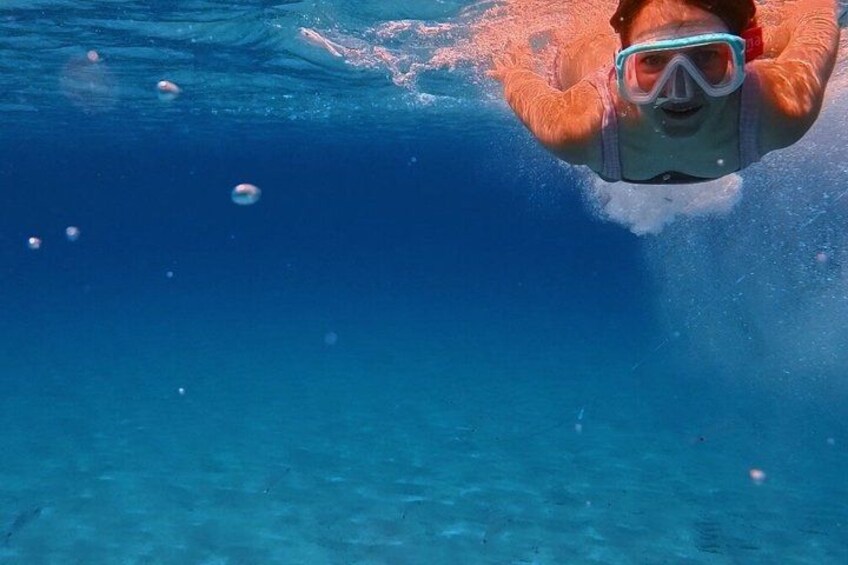 A person swimming underwater with bubbles. 5
