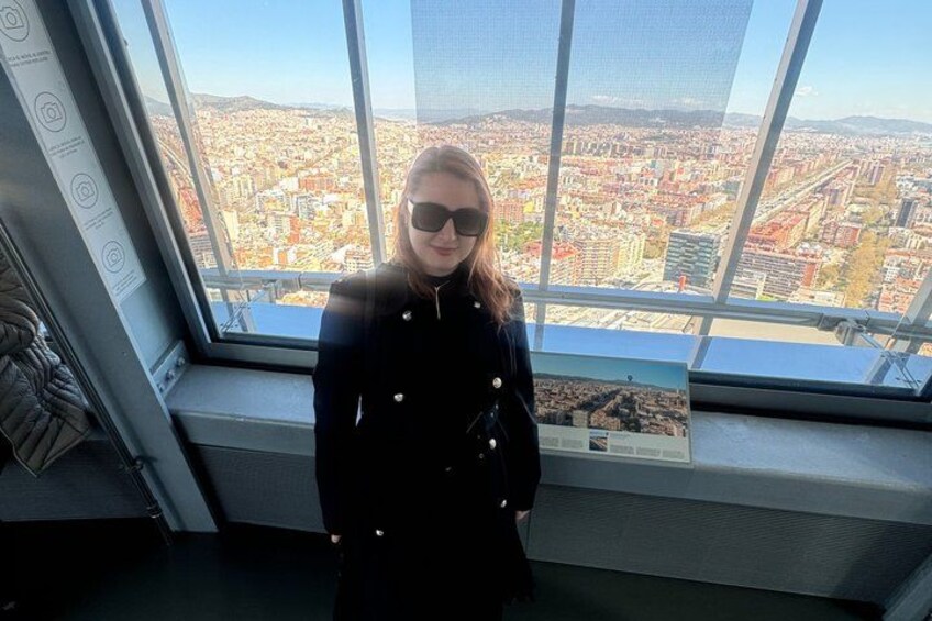A person standing by a large window with a cityscape view. 4