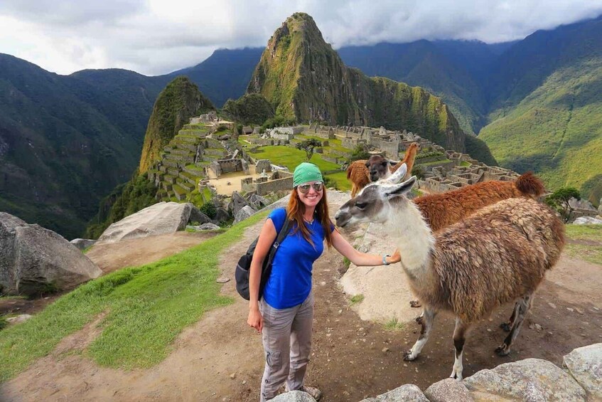Eine Person mit einem Lama vor Machu Picchu. 5