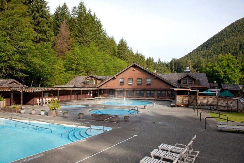 A resort with multiple swimming pools, a lodge, and a mountainous backdrop. 1