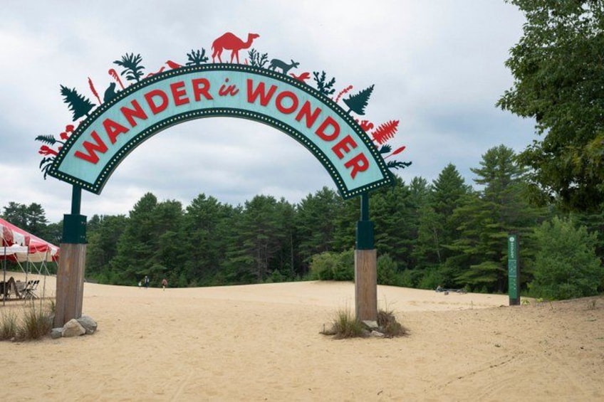 A sign with the words 'WANDER in WONDER' and various animal silhouettes. 1