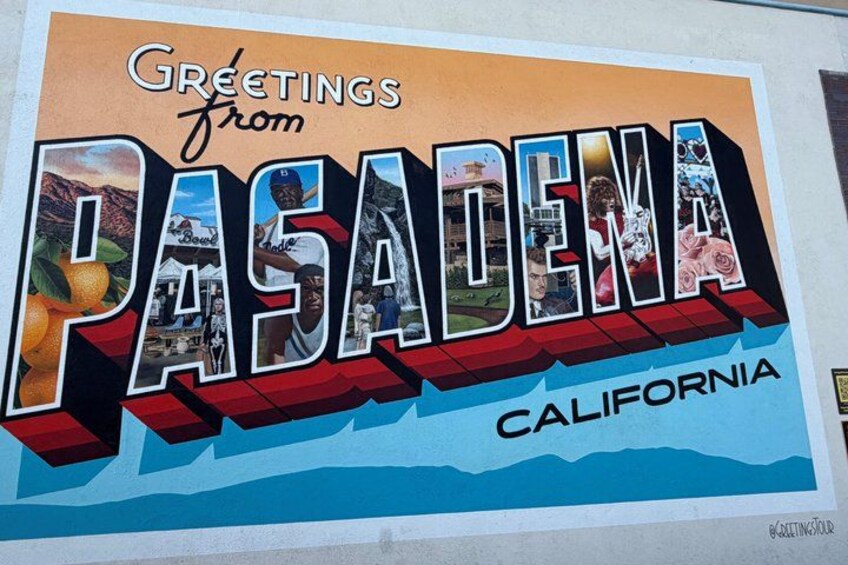 A colorful sign with the text 'Greetings from PASADENA CALIFORNIA' and various images of local landmarks and scenery. 1