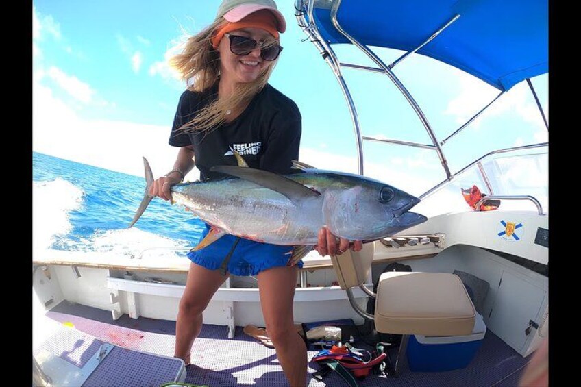A person holding a large fish on a boat. 1