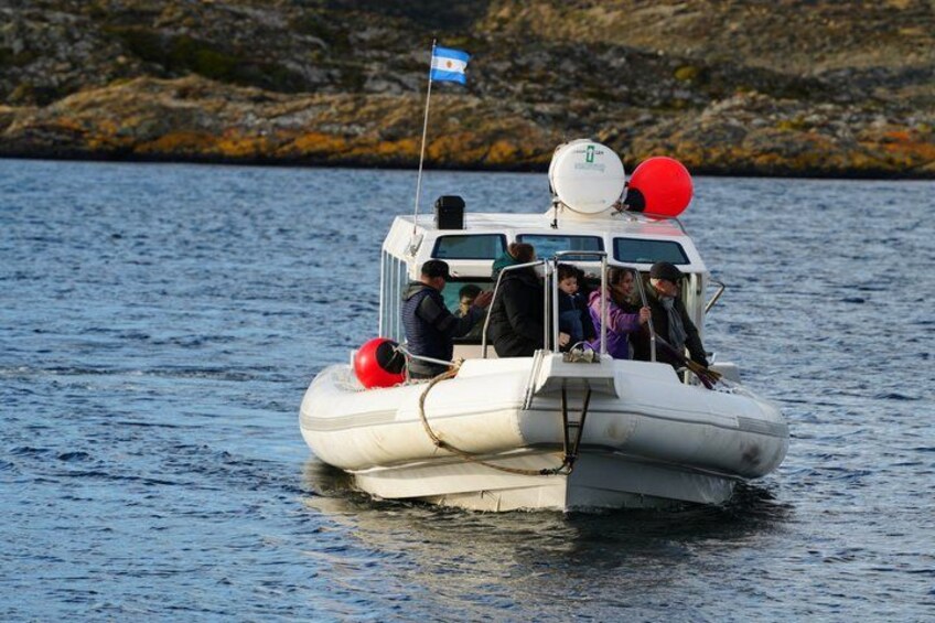 A small inflatable boat with passengers, a flag, and a red buoy. 2