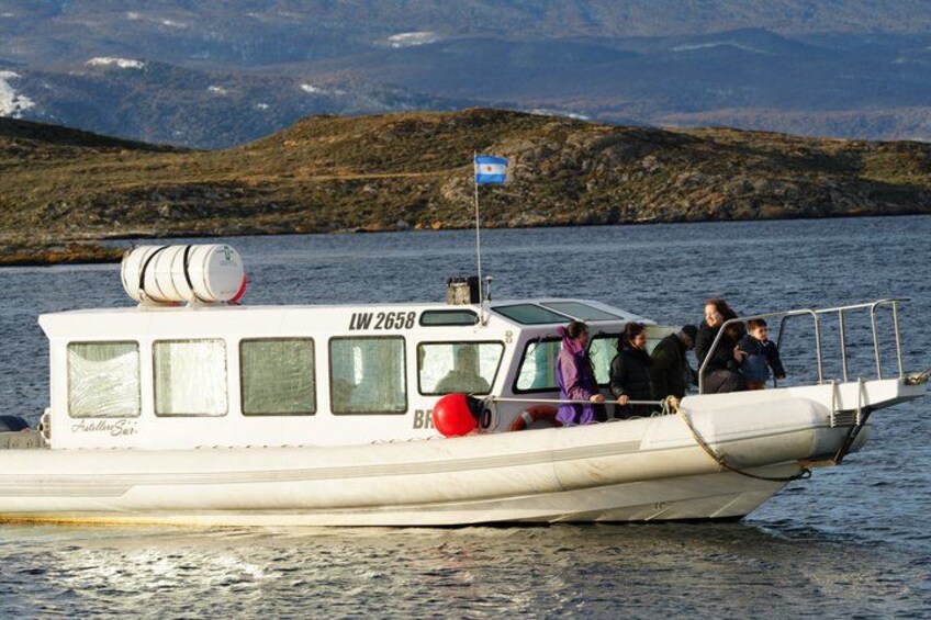 A boat with passengers, a flag, and a mountainous landscape in the background. 5