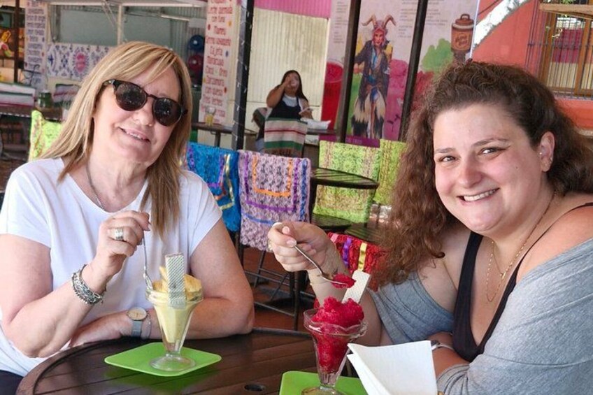 Two people sitting at a table with drinks and a colorful background. 5