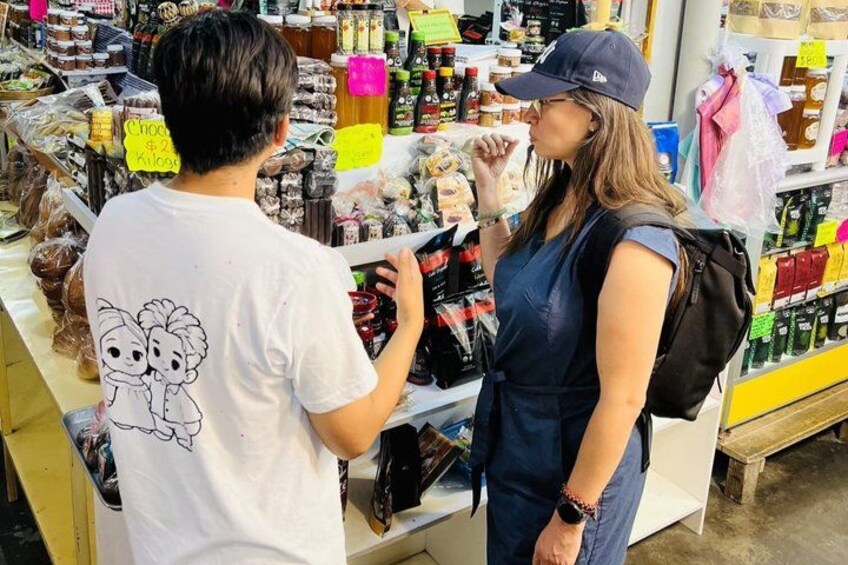 A person in a white t-shirt with a graphic design, standing in a store aisle with various packaged goods. 2