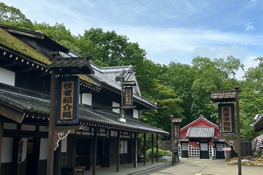 Traditional Japanese architecture with wooden buildings and a red-roofed structure. 5
