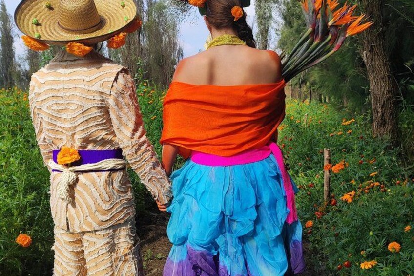 Two people walking in a field with flowers and trees. 3