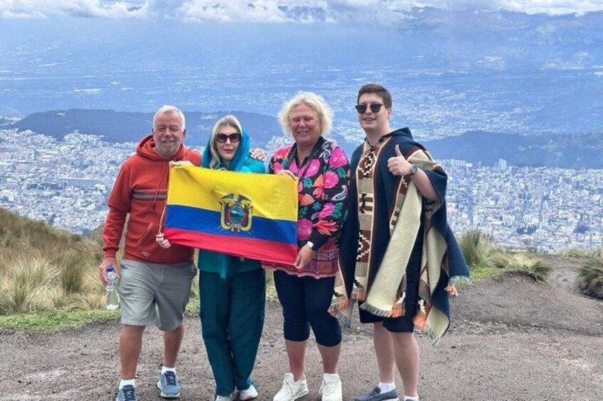 Four people standing on a hill with a cityscape in the background. 1