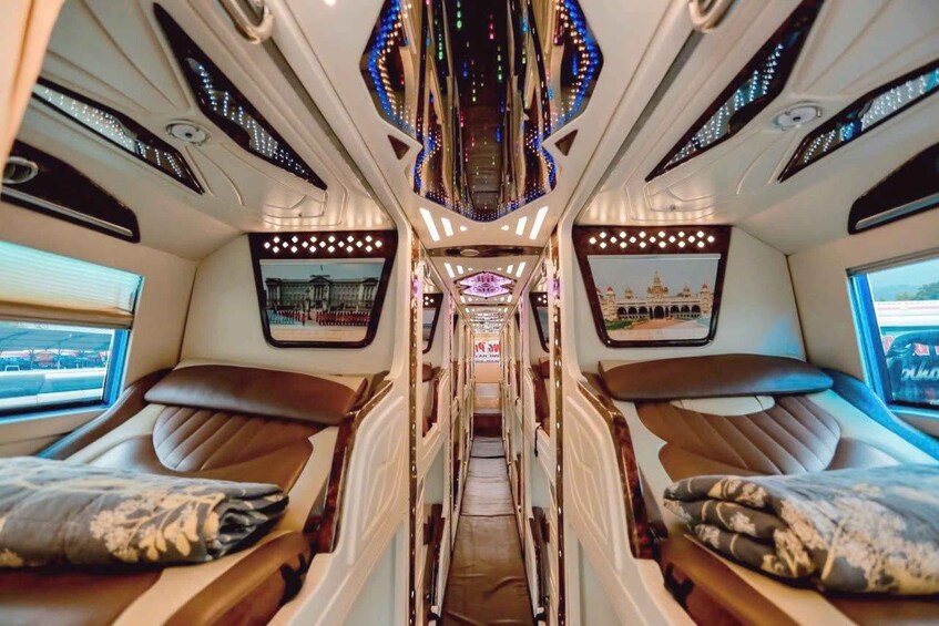 Ein luxuriöses Zuginterieur mit zwei schrägverstellbaren Sitzen, einem zentralen Gang und Deckenbeleuchtung. 3
