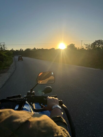 Un motocycliste circule sur une route, avec le soleil couchant en arrière-plan. 5