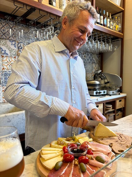 A person slicing cheese on a wooden board with a knife. 3