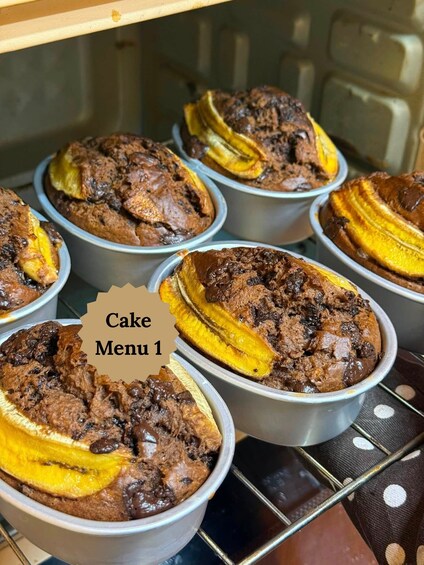 Un menu de gâteaux présentant plusieurs variétés servies dans des plats en métal, dont certains sont garnis de rondelles de banane. 2