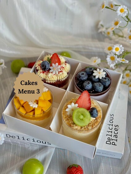 Un présentoir de desserts avec quatre gâteaux différents, chacun garni de fruits. 1