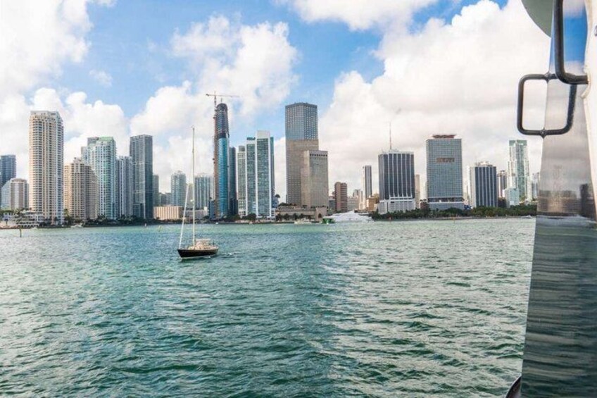 A city skyline with high-rise buildings and a sailboat on the water. 3