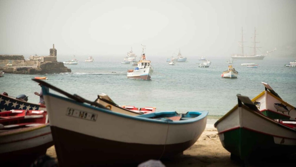 Un port où plusieurs bateaux sont amarrés, avec un phare en arrière-plan. 2