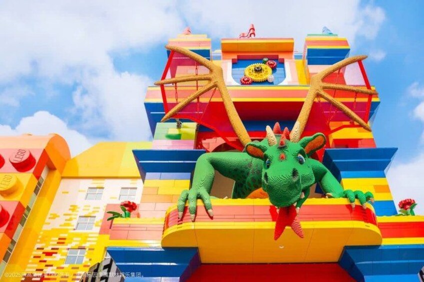A colorful building with a green dinosaur sculpture and a starfish decoration. 2
