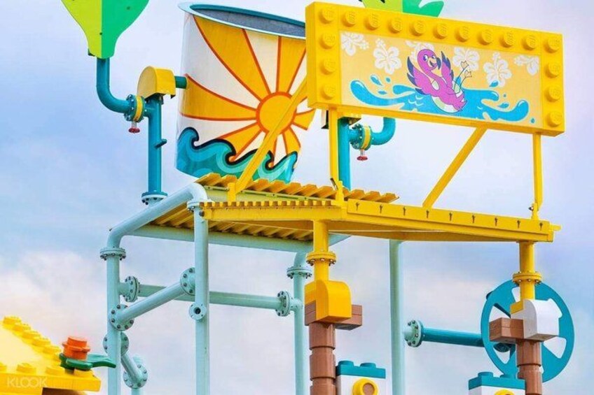 A colorful water ride structure with a sun and sea creature design, featuring a platform and support beams. 4