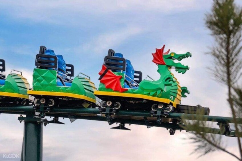 A roller coaster with dragon-themed cars. 1