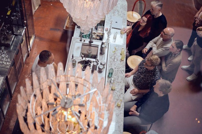 A group of people gathered around a table with a decorative chandelier above. 2