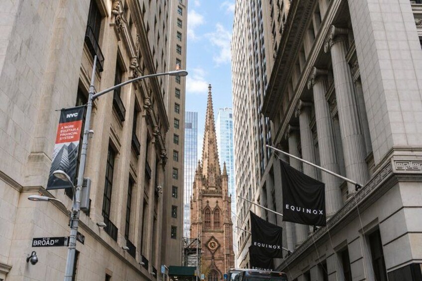 A street view with buildings, street signs, and a prominent church spire. 1
