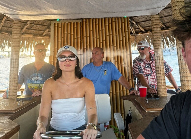 A group of people on a boat with a bamboo structure overhead. 3
