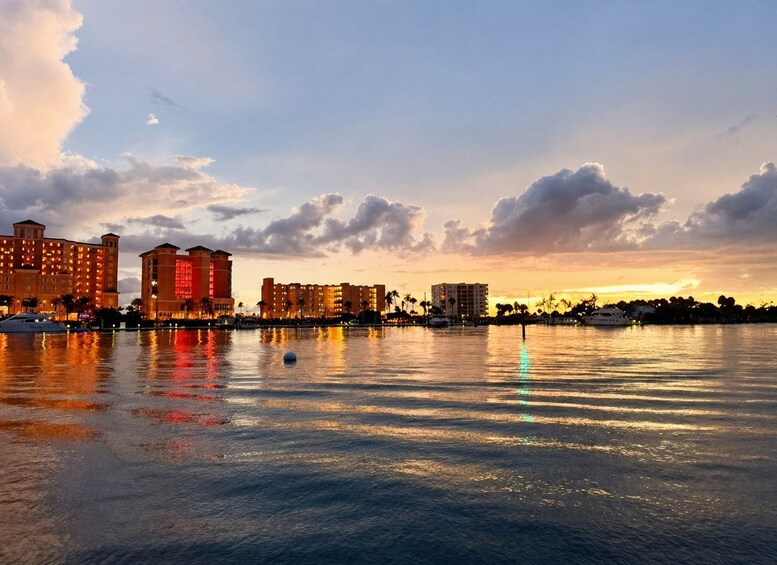 A waterfront cityscape at sunset with illuminated buildings reflecting on the water. 5