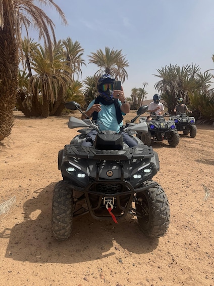 Three off-road vehicles on a sandy terrain with palm trees in the background. 2