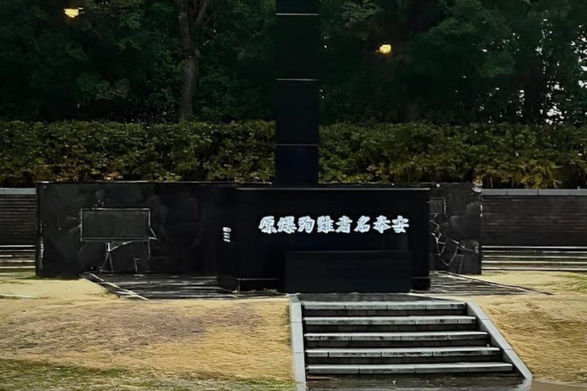 A black structure with white text, surrounded by grass and a metal staircase. 5