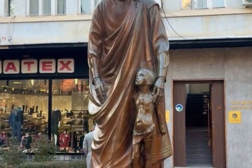 A statue in front of a building with a sign that reads 'ATEX'. 5