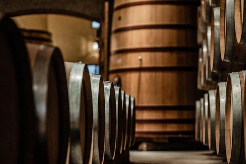 Wooden barrels arranged in rows inside a building. 1