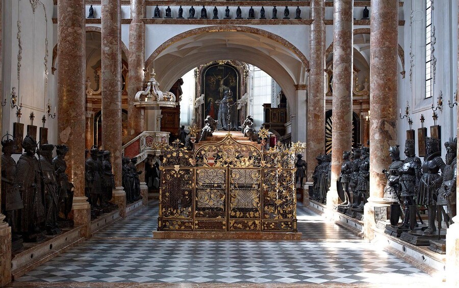 Una capilla ornamentada con un altar central, rodeada de estatuas y columnas. 3