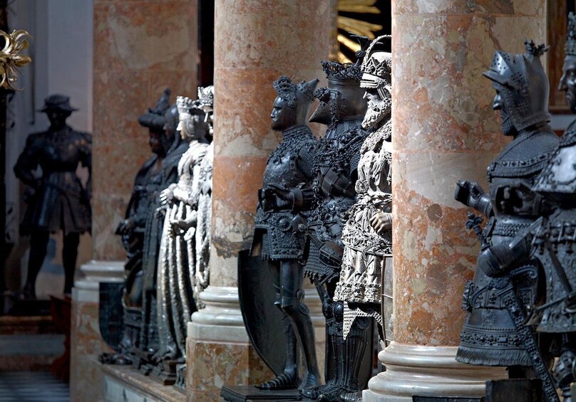 Una hilera de estatuas de bronce que representan figuras con armadura en un edificio histórico. 5