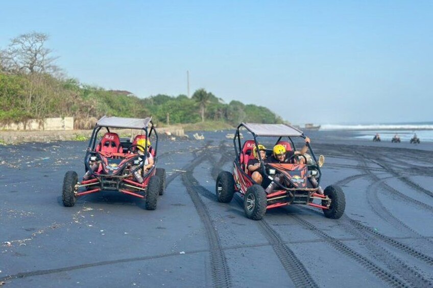 Two off-road vehicles on a sandy beach with tire tracks. 4