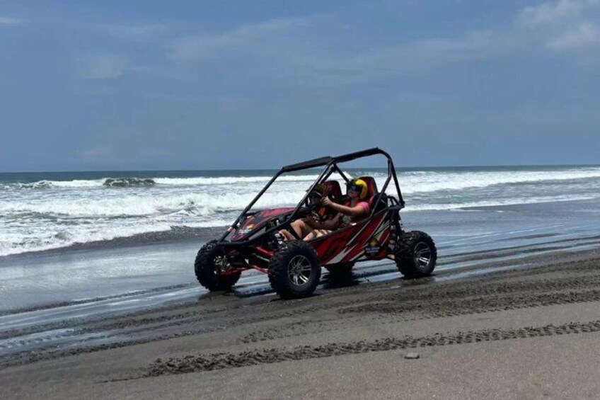 A dune buggy on a beach with waves in the background. 3